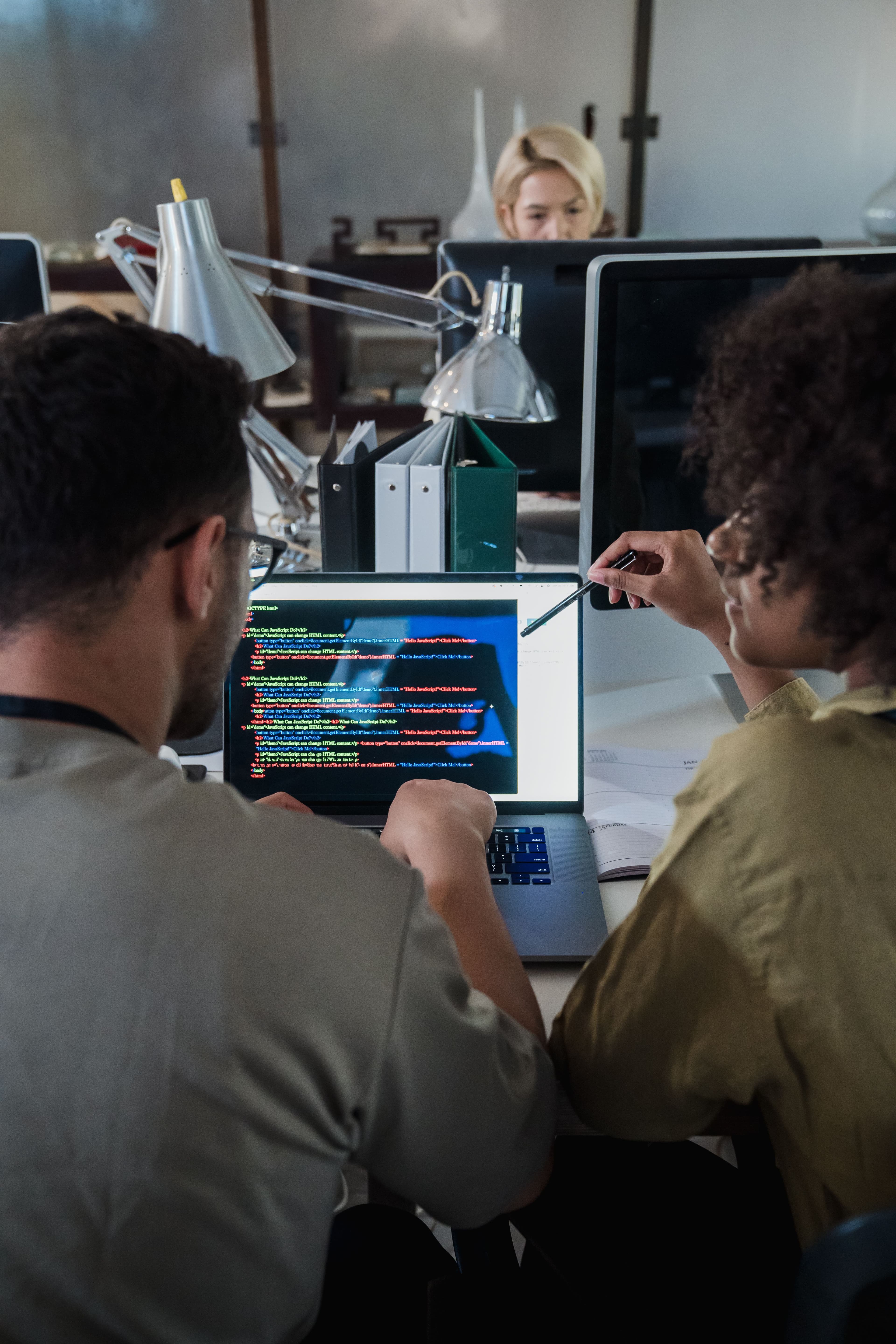 Man and Woman in front of laptop with code
